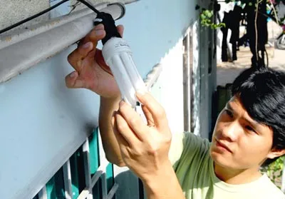 Thay đèn huỳnh quang bằng đèn compact tại khu nhà trọ số 72 phường Linh Trung. Ảnh: K. NGÂN